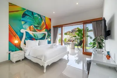 a bedroom with a white bed and a painting at Viewbali 2- Modern Villa with Stunning Rooftop Views in Kerobokan