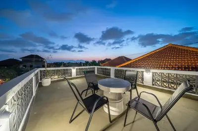 a patio with chairs and a table on a balcony at Viewbali 2- Modern Villa with Stunning Rooftop Views in Kerobokan