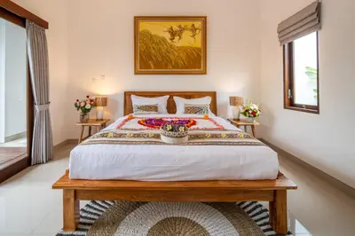 a bedroom with a large bed and two tables at Arts Biyu Villa Two-Bedroom with Private Pool Kuta in Seminyak
