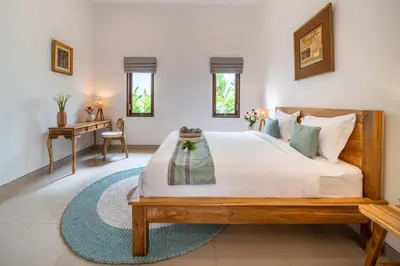 a bedroom with a large bed and a desk at Arts Biyu Villa Two-Bedroom with Private Pool Kuta in Seminyak
