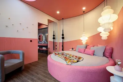 a bedroom with a large pink bed with a chair at CANGGU BRAND NEW 6Bed VILLA! BEST LOCATION! A STEP-FREE Design Highlight for Families & Friends in Canggu