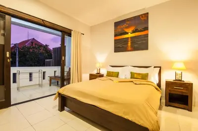 a bedroom with a large bed and a large window at 4-BR Private Pool Legian Villa, 5-min walk to beach and shops in Seminyak