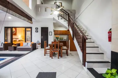 a living room with a staircase and a dining room at 4-BR Private Pool Legian Villa, 5-min walk to beach and shops in Seminyak