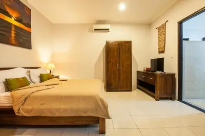 a bedroom with a bed and a television in it at 4-BR Private Pool Legian Villa, 5-min walk to beach and shops in Seminyak