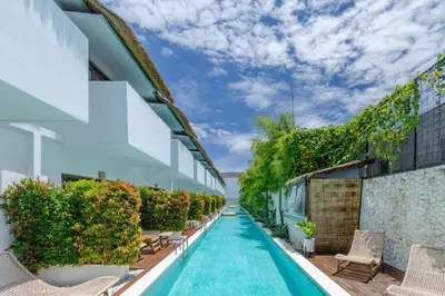 an infinity pool with chairs and plants on the side of a building at Baliterraneo Boutique Resort Seminyak in Seminyak