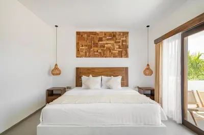 a bedroom with a white bed and a window at Baliterraneo Boutique Resort Seminyak in Seminyak
