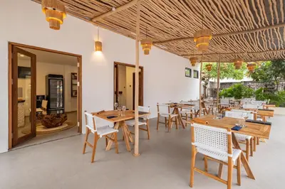 a dining room with wooden tables and chairs at Baliterraneo Boutique Resort Seminyak in Seminyak