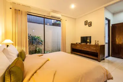 a bedroom with a large bed and a television at 8-BR Private Pool Legian Villa 5-min Walk to Beach and Shops in Seminyak