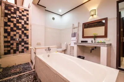 a bathroom with a tub and a toilet at 7-BR Private Pool Legian Villa 5-Min Walk to Beach and Shops Bali in Seminyak