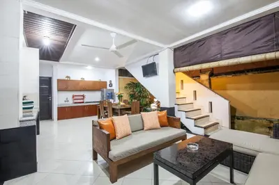 a living room with a couch and a staircase at 7-BR Private Pool Legian Villa 5-Min Walk to Beach and Shops Bali in Seminyak