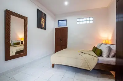 a bedroom with a bed and a mirror at 6-BR Garden Legian Villa 5-Min Walk to Beach and Shops Bali in Seminyak