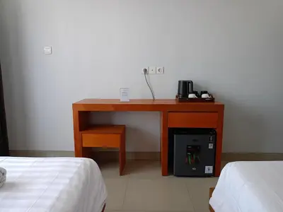 a desk in a room with a table and a desk with a phone at Ronta Bungalows in Legian