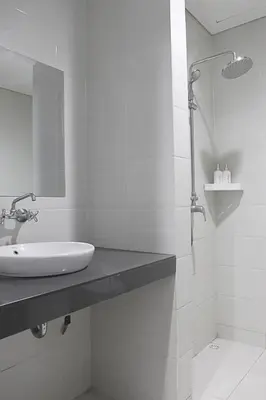 a white bathroom with a sink and a shower at Ronta Bungalows in Legian