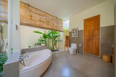 a bathroom with a large tub and a toilet at Villa Lea - 5BR luxury oasis in Seminyak with pool in Kerobokan