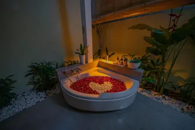a bath tub filled with red peppers in a room with plants at Villa Lea - 5BR luxury oasis in Seminyak with pool in Kerobokan