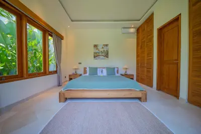 a bedroom with a bed and two windows at Villa Lea - 5BR luxury oasis in Seminyak with pool in Kerobokan
