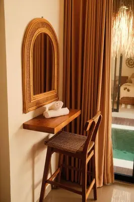 a dressing table with a chair and a mirror at Amethyst Villa Seminyak in Seminyak