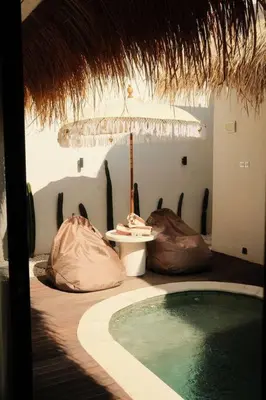 a bathroom with a swimming pool and a umbrella at Amethyst Villa Seminyak in Seminyak