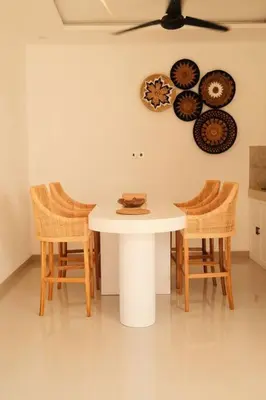 a white table with chairs and plates on the wall at Amethyst Villa Seminyak in Seminyak