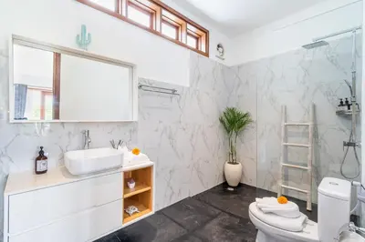 a white bathroom with a sink and a toilet at Villa Gea by JB Villas in Seminyak