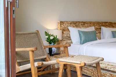 a bedroom with a bed and a chair and a bed at Arts Cherry Villa Satu Two-Bedroom with Private Pool Kuta in Kerobokan