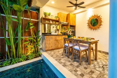 a kitchen with a dining table and a swimming pool at Arts Cherry Villa Dua Two-Bedroom with Private Pool Kuta in Kerobokan