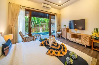 a room with a bed with a doll on it at Arts Cherry Villa Dua Two-Bedroom with Private Pool Kuta in Kerobokan