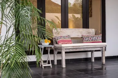 a bench sitting on a porch with pillows on it at Bens Seminyak Villa Two-Bedroom with Private SwimmingPool in Seminyak