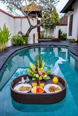 a table with plates of food in a swimming pool at Bens Bidadari Villa Two-Bedroom with Private Pool Kuta in Seminyak