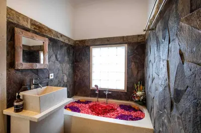 a bathroom with a large tub filled with flowers at Bens Kenanga Villa Three-Bedroom with Private Pool Kuta in Kerobokan