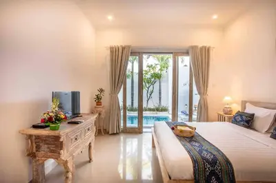 a bedroom with a bed and a desk with a television at Bens Kenanga Villa Three-Bedroom with Private Pool Kuta in Kerobokan