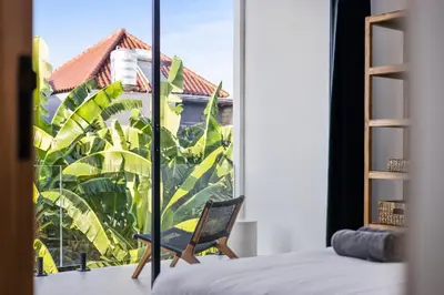 a bedroom with a view of a window with a chair at White Residence - Art & Boutique Villas in Seminyak