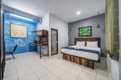a bedroom with a bed and a desk in it at Senyum Bali Inn 1BR Sanur in Sanur
