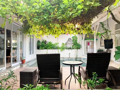 a patio with two chairs and a table with plants at Tropical Oasis 2 BR Villa - Near Beach in Seminyak