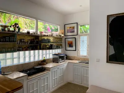 a kitchen with white cabinets and two windows at Tropical Oasis 2 BR Villa - Near Beach in Seminyak