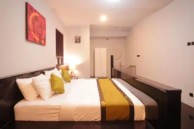 a bedroom with a large bed with yellow and white pillows at Amaya Residence Jimbaran in Jimbaran