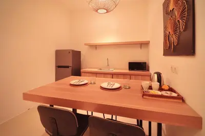 a kitchen with a large wooden table with two chairs at Amaya Residence Jimbaran in Jimbaran