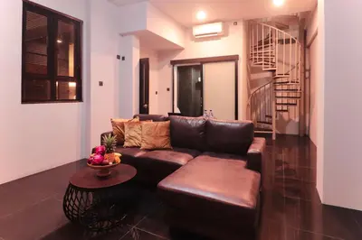 a living room with a brown couch and a table at Amaya Residence Jimbaran in Jimbaran