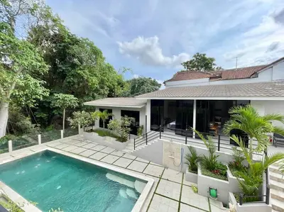 a swimming pool in front of a house at Villa EM Umalas by Satran Villa in Kerobokan