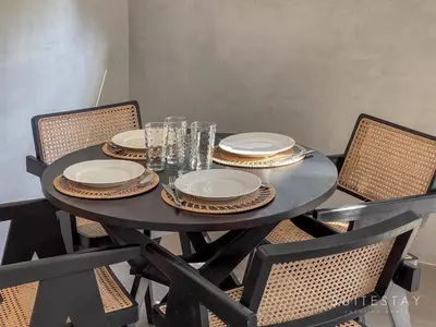 a black table with plates and glasses on it at Modern Duplex With Stylish Design in Canggu