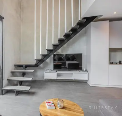 a living room with a staircase and a table at Modern Duplex With Stylish Design in Canggu