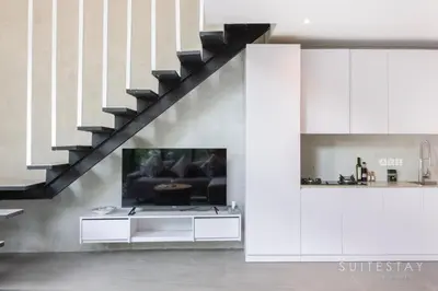 a living room with a couch and a staircase at Modern Duplex With Stylish Design in Canggu