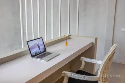 a laptop computer sitting on a white desk with two chairs at Modern Duplex With Stylish Design in Canggu