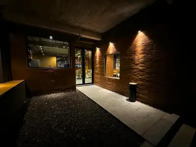 a dark room with a door and a brick building at Althia Private Capsule Quarters in Badung