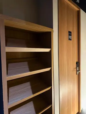 a closet with wooden shelves and a door at Althia Private Capsule Quarters in Badung