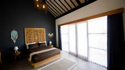 a bedroom with a bed and a large window at Villa La madrina in Kerobokan