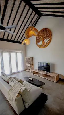 a living room with a couch and a tv at Villa La madrina in Kerobokan