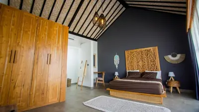 a bedroom with a bed and wooden cabinets at Villa La madrina in Kerobokan