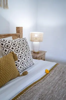 a bedroom with a bed with pillows and a lamp at Bali Huis Villa in Seminyak