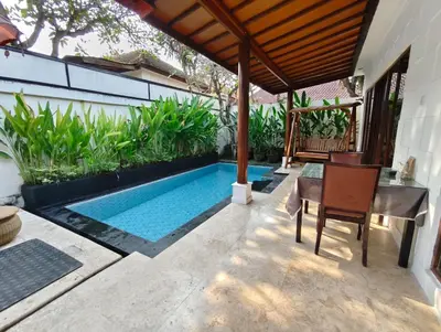 a backyard with a swimming pool and a table and chairs at Privat Pool Villa at Kuta in Kuta
